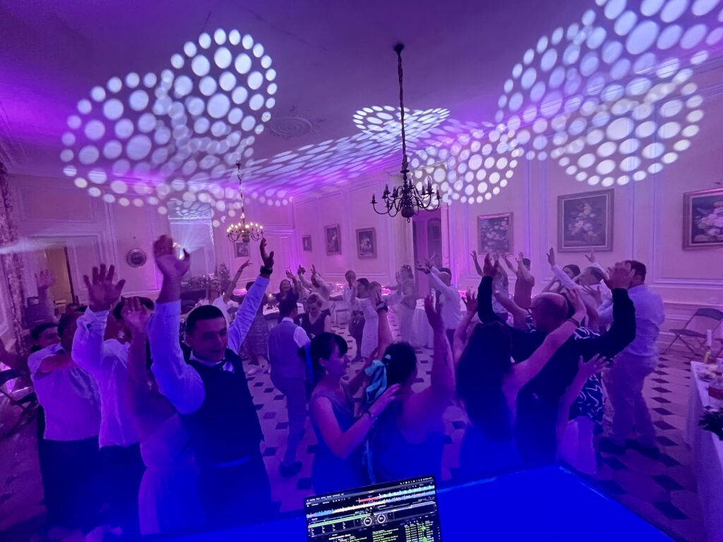 Invités dansant sous un éclairage violet lors d'une soirée de mariage