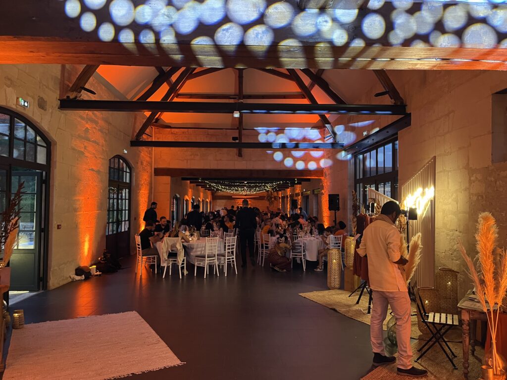 Salle de réception de mariage mise en lumière avec un éclairage ambré