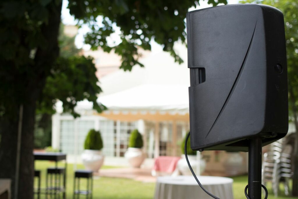 Enceinte de sonorisation installée en extérieur devant un château pour un cocktail de mariage